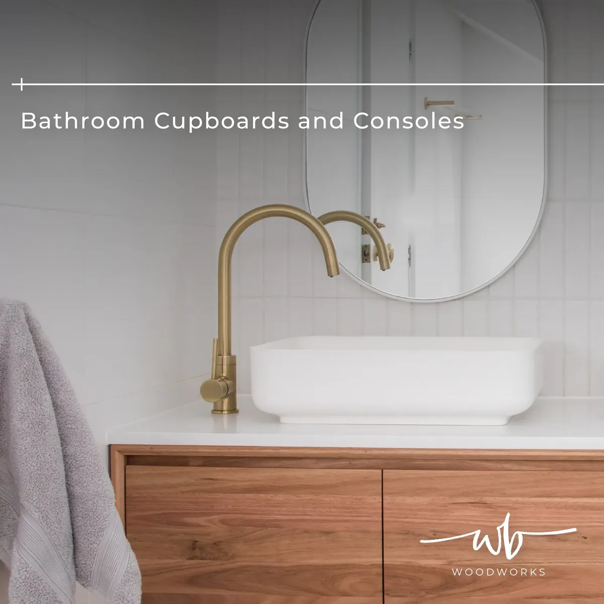 Timber bathroom vanity cupboard beneath a white basin, brushed brass tap and oval mirror